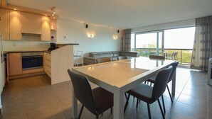 Una cocina moderna con una isla central, horno integrado y amplio espacio en la encimera.