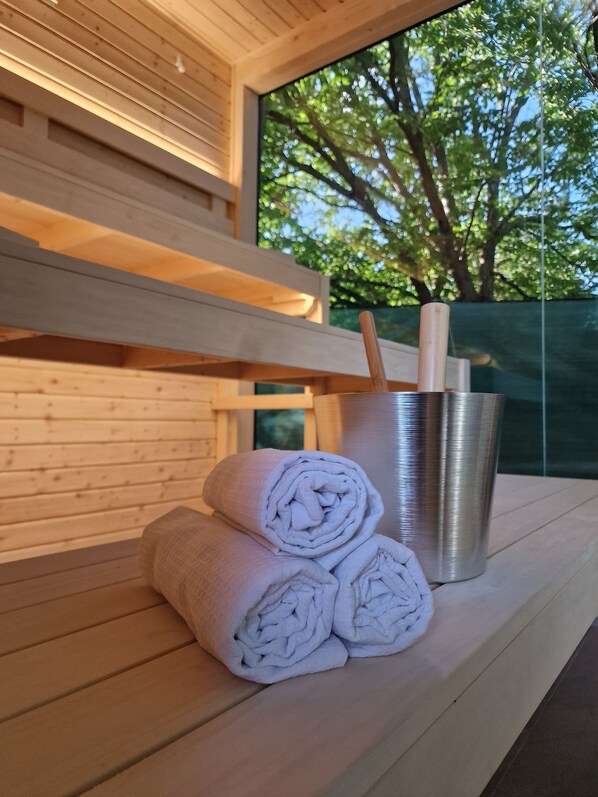 A wooden bench with towels and a thermos.