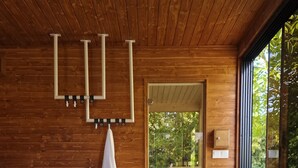 Un jacuzzi con revestimiento de madera, una toalla colgada en un perchero y una puerta que da al exterior.