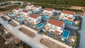 A modern resort with multiple white buildings, each with a swimming pool and outdoor seating areas. - Apartment in Croatia Near Adriatic Coast (Sukosan)