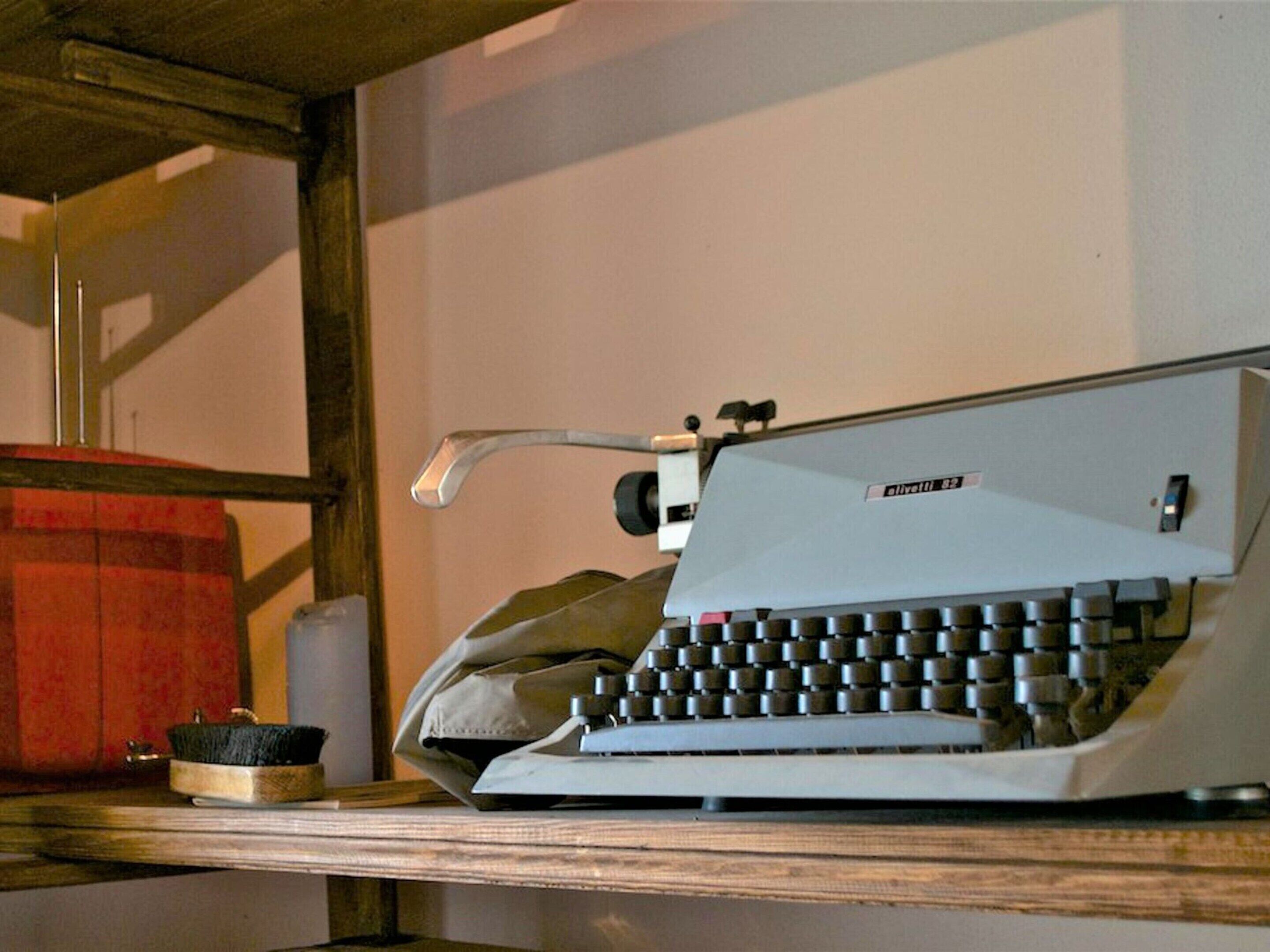 A vintage Olivetti 101 typewriter on a wooden desk.
