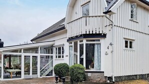 A white building with a sloped roof, large windows, and a covered patio area. - 9 Person Holiday Home in Tjodalyng-by Traum (Larvik)