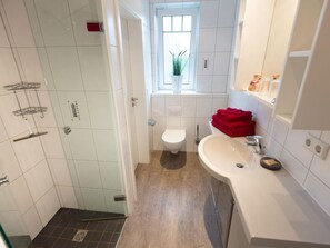 A modern bathroom with a shower, toilet, and sink. - Holiday Home Nige Og (Cuxhaven)