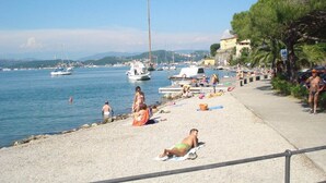 A beach with people sunbathing and swimming, boats in the water, and a clear sky. - Quiet and secluded, close to Cinque Terre, Porto Venere, Lerici, and Tellaro (Le Grazie)