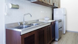 A kitchen with a double sink, a stove, and a refrigerator. - Quiet and secluded, close to Cinque Terre, Porto Venere, Lerici, and Tellaro (Le Grazie)