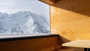 Une cabane en bois offrant une vue sur des montagnes enneigées.