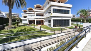 Un hôtel moderne à plusieurs étages, doté de balcons, de grandes fenêtres et d’une pelouse bien entretenue.