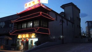 A building with a neon sign and traditional architectural elements. - Hongfulou Hostel (Shilin)