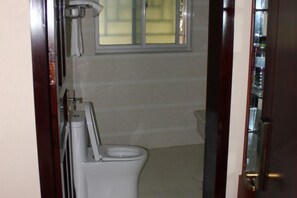 A small bathroom with a toilet, a towel rack, and a window. - Hongfulou Hostel (Shilin)