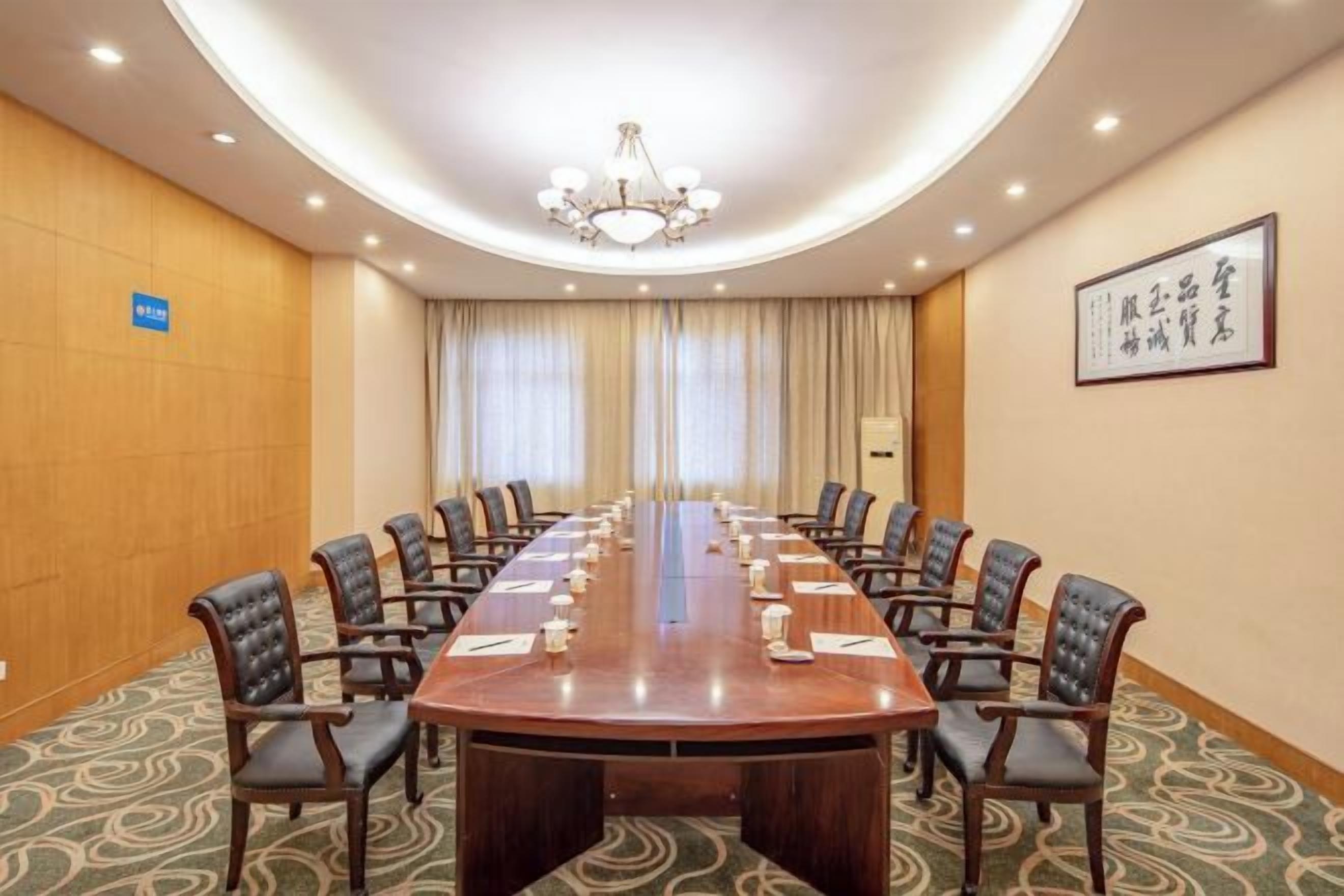 A conference room with a long table, chairs, and a chandelier.