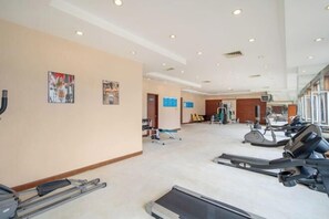 Uma academia com esteiras, bicicletas ergométricas e aparelhos de musculação.