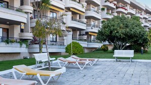 Un hôtel à plusieurs étages doté de balcons, d’un espace extérieur aménagé et de verdure.