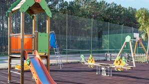 Une aire de jeux avec un toboggan, des balançoires et des structures d’escalade.