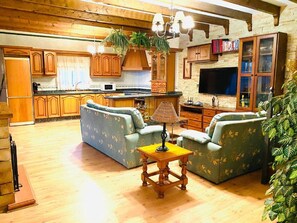 A spacious living area with a sofa set, a wooden coffee table, and a television. - Belvilla by oyo Home Holidays Casa Rural Tijoco (Adeje)