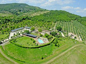 Un vaste domaine comprenant une piscine, plusieurs bâtiments et de vastes étendues de verdure.