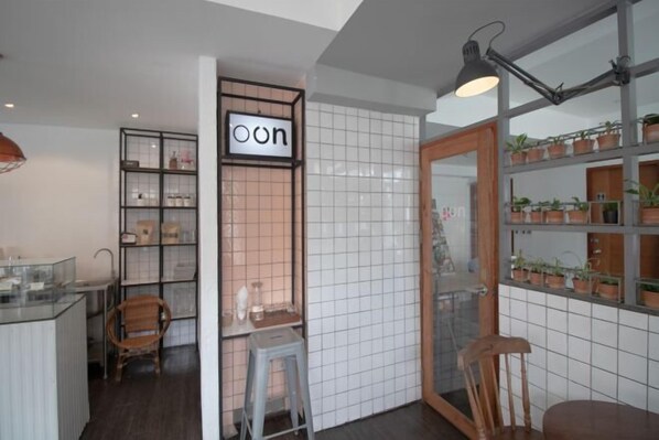 Una cocina moderna con azulejos blancos, un aparador de vidrio y una silla de madera.