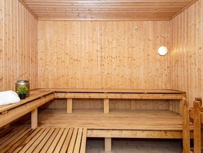 Un sauna avec des murs et des bancs en bois.