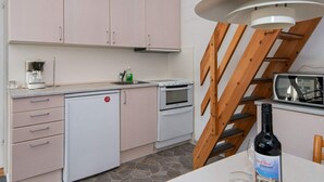 A kitchen with a built-in oven, a coffee maker, and a microwave. - 8 Person Holiday Park Home in Ringkobing (Ringkobing)