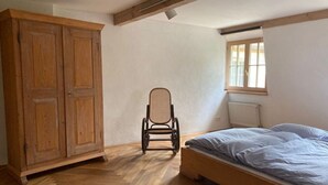 Una habitación con cama, una silla y un armario.