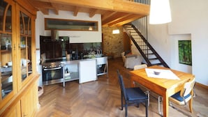 Un loft espacioso con cocina, comedor y una escalera que lleva a un nivel superior.