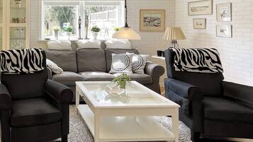 A living room with a sofa set, a coffee table, and a rug.