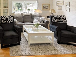 A living room with a sofa set, a coffee table, and a rug. - 4 Star Holiday Home in Farjestaden (Farjestaden)