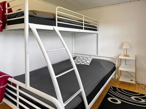 A bunk bed with a ladder, a bedside table with a lamp, and a patterned rug. - 4 Star Holiday Home in Farjestaden (Farjestaden)