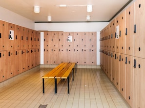 A locker room with multiple wooden lockers, a wooden bench, and a tiled floor. - 6 Person Holiday Park Home in Blavand (Blavand)