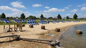 A beach with rows of blue lounge chairs and a sandy shoreline. - Romantic Boathouse Getaway in Lathum (Lathum)
