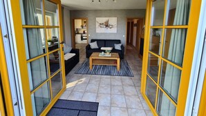 A spacious living area with a sofa set, a coffee table, and a painting on the wall. - "moseltor" Comfortable Holiday Residence (Monzelfeld)