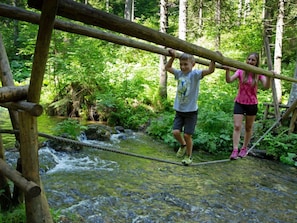 A wooden bridge over a stream in a forested area. - Apartment in Hohentauern Near the ski Area (Hohentauern)