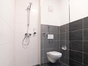 A bathroom with a shower, toilet, and towel rack. - Apartment in Hohentauern Near the ski Area (Hohentauern)