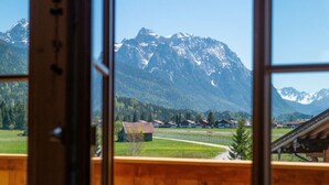 A mountain view through a window, with a wooden cabin structure in the foreground. - No. 2 - Country House Geierstanger (Wallgau)
