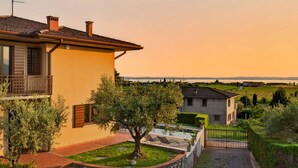 A residential property with a balcony, a stone wall, and a view of the countryside. - Regarda - Villa Celebrity with private pool and stunning lake view (Lazise)