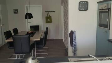 A modern kitchen with a built-in oven and a clock on the wall.