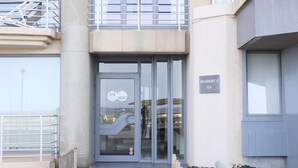 A building entrance with a glass door, a metal staircase, and a sign reading "SEASIGHT A 121".