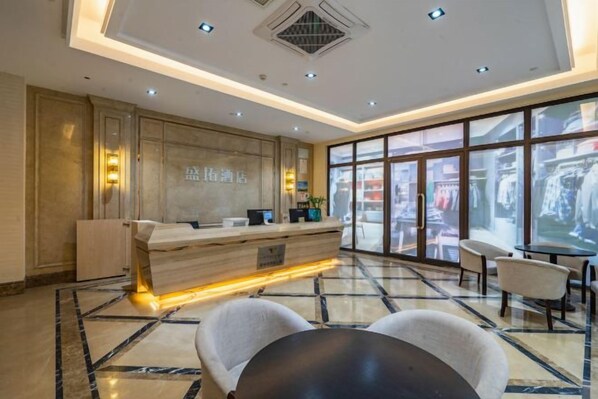 A hotel lobby with a reception desk, seating area, and large windows. - Hangzhou Tonglu Shengtuo Serviced Apartment (Tonglu East Station Jiangnan Town) (Tonglu)