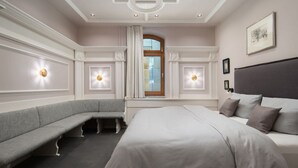 A bedroom with a large bed, a bench, and two wall-mounted lights. - Maria Luise Comfortable Holiday Residence (Bad Harzburg)