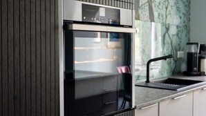 A modern kitchen with a built-in oven and a coffee machine on the counter. - Maria Luise Comfortable Holiday Residence (Bad Harzburg)