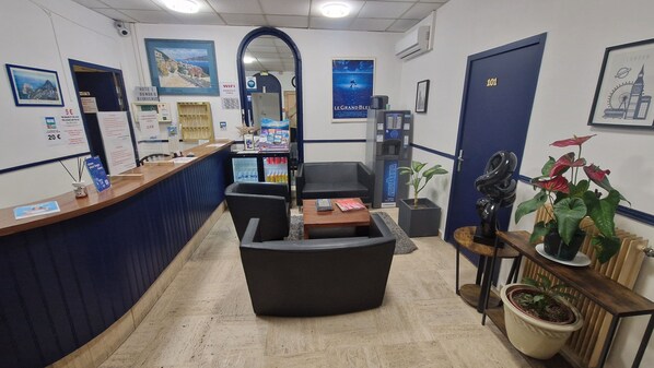 A reception area with a counter, seating, a mirror, and a door marked 101. - HOTEL DU NORD (Cannes)