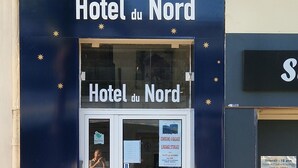 The exterior of Hotel du Nord with a blue facade, star decorations, and a red rope barrier. - HOTEL DU NORD (Cannes)