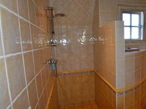 A bathroom with a shower, tiled walls, and a window. - Spacious Holiday Home Close to the sea (Burgerbrug)