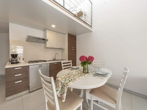 Enjoy meals in the kitchen with a gas stove, oven, and dishwasher, and dine at the round table with four chairs.