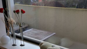 A window sill with a small table, a vase with dried flowers, and a couple of decorative spheres. - Ostseeliebe Comfortable Holiday Residence (Schönberg)