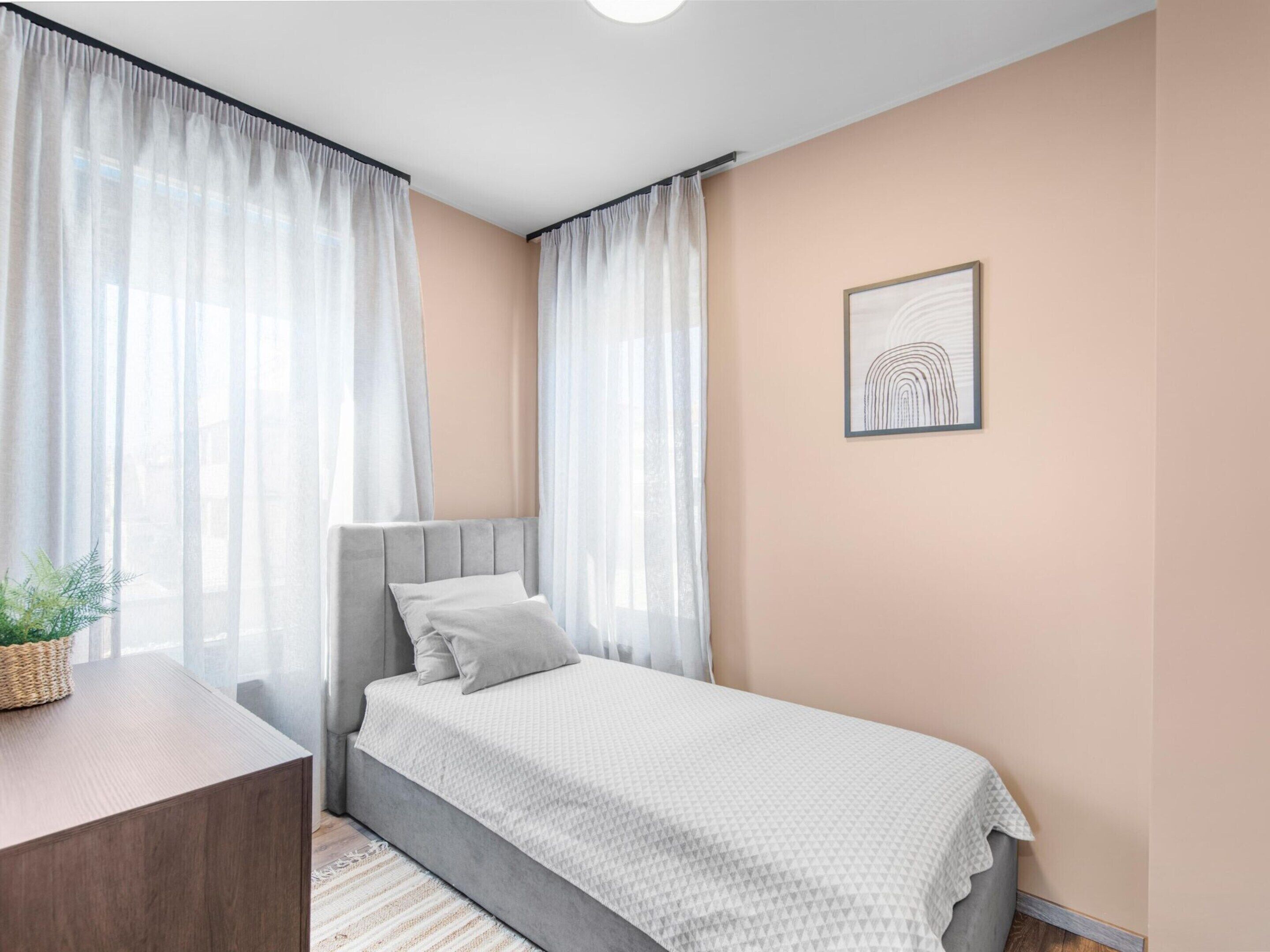 A bedroom with a bed, a bedside table, and a wall-mounted picture.