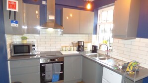 A compact kitchen with a microwave, stove, oven, sink, and various appliances. - Historic Old Town Home with Views and free parking (Kingston upon Hull)