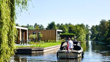 Un bateau sur un canal, avec un bâtiment moderne en arrière-plan.