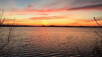 A calm body of water with a sunset sky.