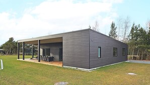 A modern, single-story house with a covered patio area. - 9 Person Holiday Home in Vaeggerlose (Vaeggerlose)