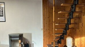 A modern living room with a wooden staircase, a fireplace, and a cozy rug. - Waldhaus No.15 Modern Retreat (Monkebude)